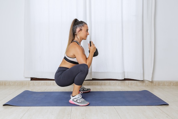 Photo athletic woman doing squats with weight