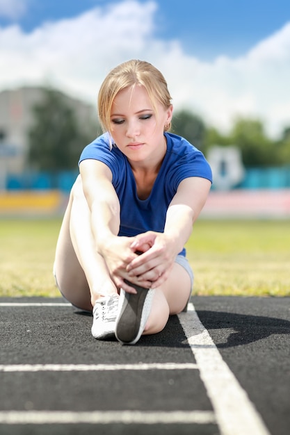 屋外でストレッチ運動をしている運動女性