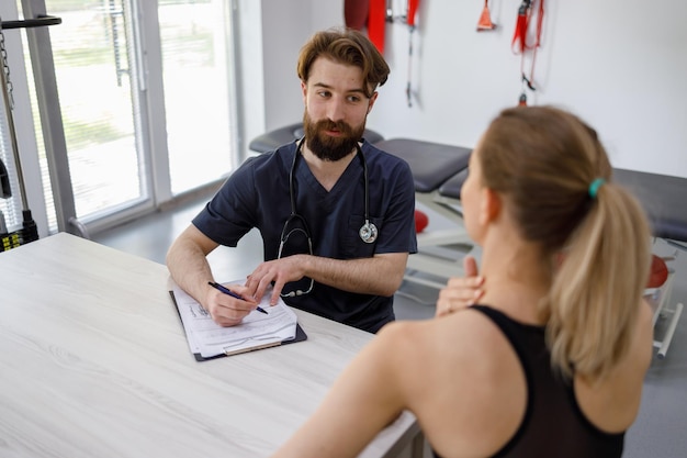 Foto la donna atletica durante una consultazione in una clinica di riabilitazione lamenta dolore al collo