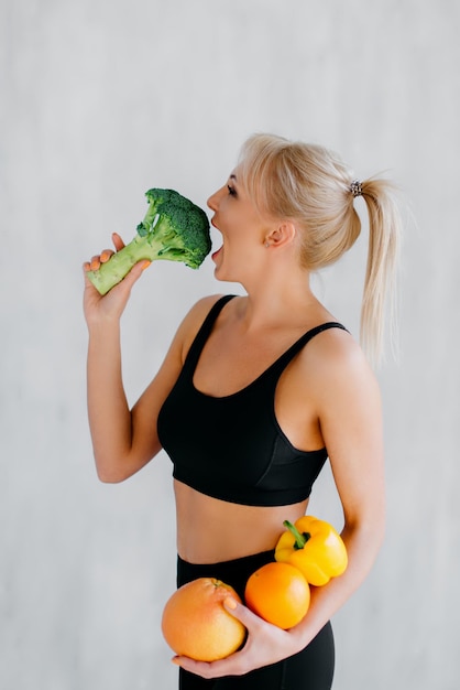 Photo athletic woman encourages eating healthy food