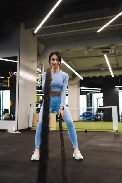 Athletic woman exercising endurance with ropes