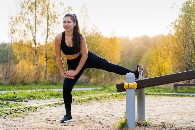 Спортивная (ый) женщина, тренирующаяся на улице в парке