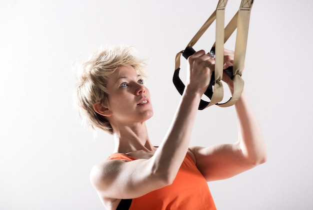 Athletic woman pulling fitness cords