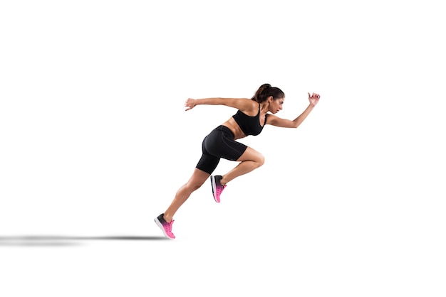 Athletic woman runner in sportswear on the asphalt of a road isolated on white wall