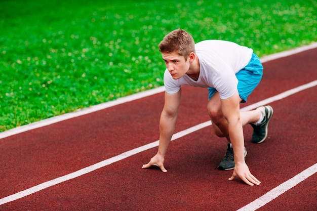 Foto atletica donna in pista iniziando a correre. concetto di fitness sano con stile di vita attivo.