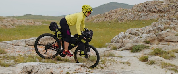 운동하는 여성 여행자는 자전거를 타고 언덕을 타고 있고 아름다운 그림 같은 계곡 개념은 주말 여행 스포츠 휴가를 즐기고 있습니다