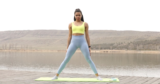 Athletic young black woman in sports dress doing fitness exercise.