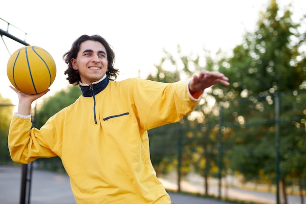 Athletic young boy in casual wear keen on basketball