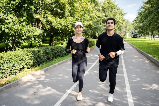 Athletic young couple trains runs down the street in running shoes healthy lifestyle