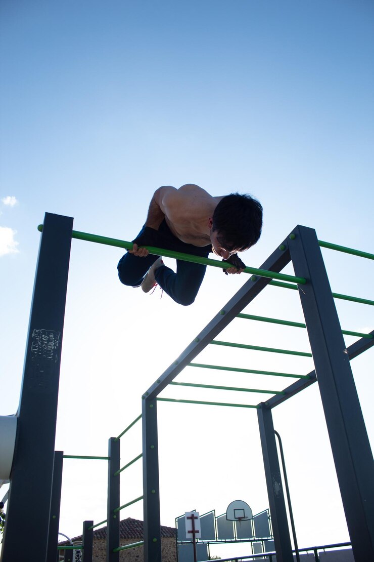 Photo athletic young man doing skin the cat exercise during advanced workout
