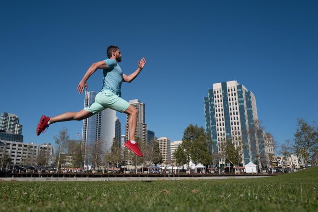 Athletic young man running in city san diego urban sport concept