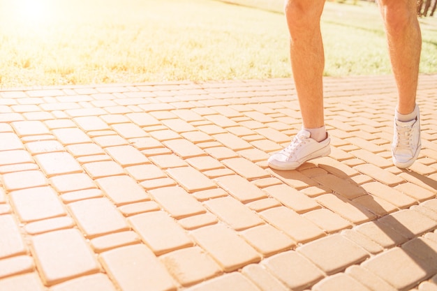Athletic young man running in the nature. healthy lifestyle. bearded black haired sportsman is running on road - sunset back lit.