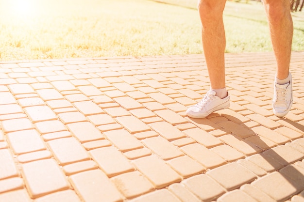 Athletic young man running in the nature. Healthy lifestyle. Bearded black haired sportsman is running on road - sunset back lit.