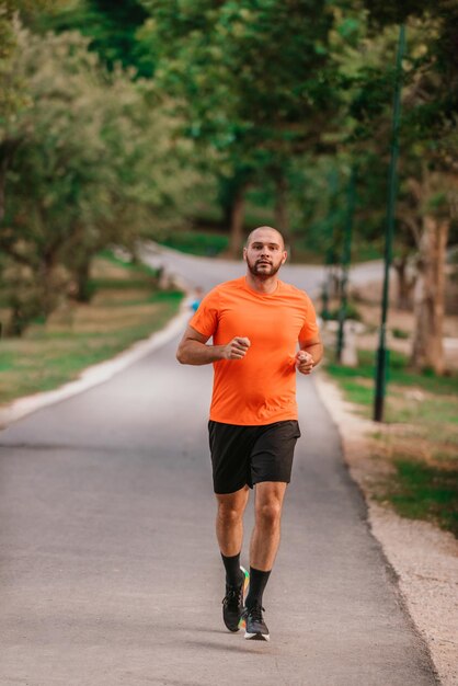 自然の中で走っている運動の若い男 健康的なライフ スタイル