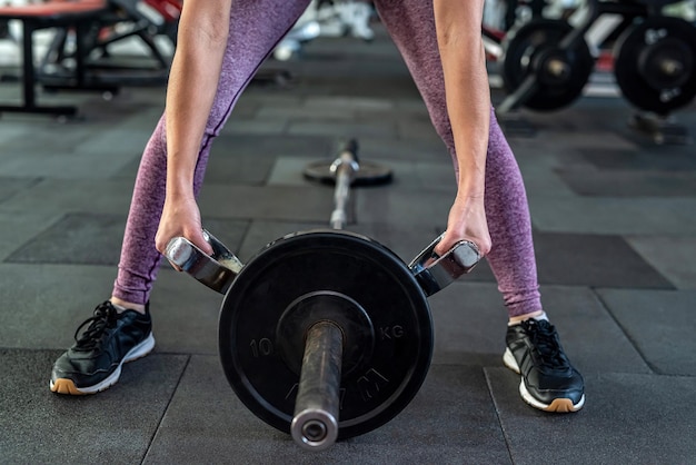 写真 ジムでバーベルを持ち上げる運動をしている運動の若い女性デッドリフトとトレーニング