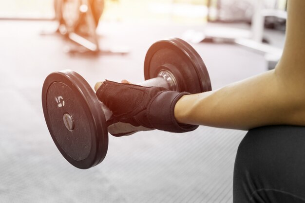 athletic young woman doing a fitness workout with dumbbell