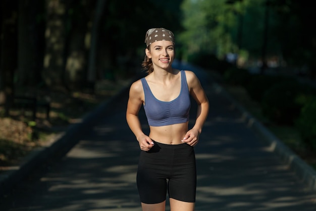 Athletic young woman in sportswear jogging in the park Fitness and healthy lifestyle