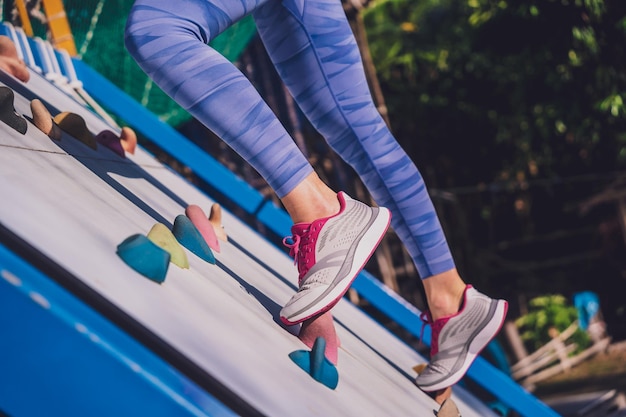 Photo athletic young woman working out and climbing at the artificial rock in training camp