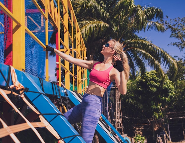 Athletic young woman working out and climbing a ropes at the rope training camp