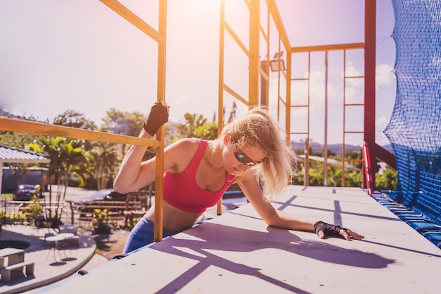 Photo athletic young woman working out and climbing a ropes at the rope training camp