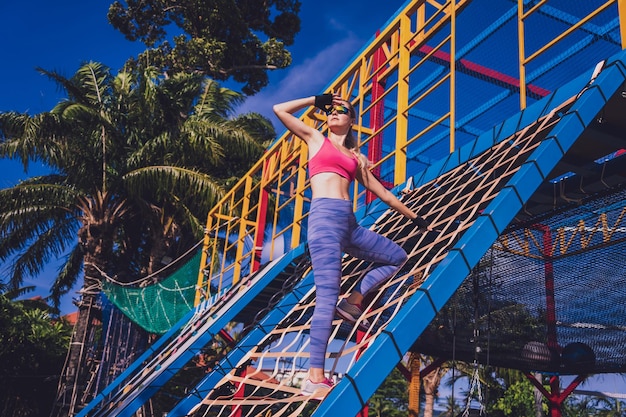 Foto giovane donna atletica che si allena e si arrampica al campo di addestramento