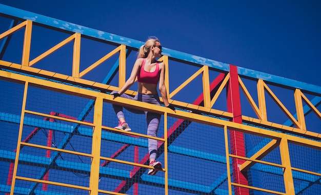 Athletic young woman working out and climbing at the training camp