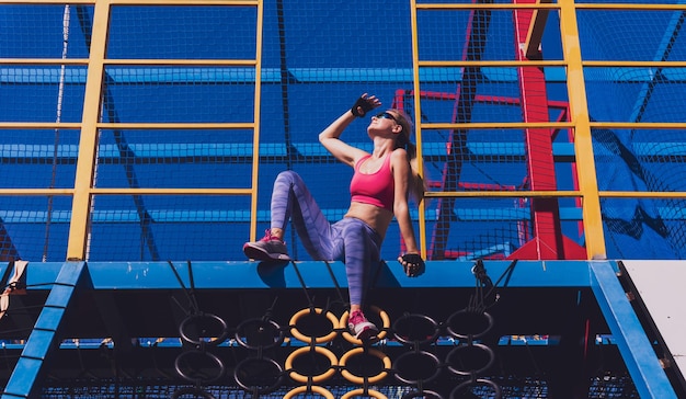 Athletic young woman working out and climbing at the training camp