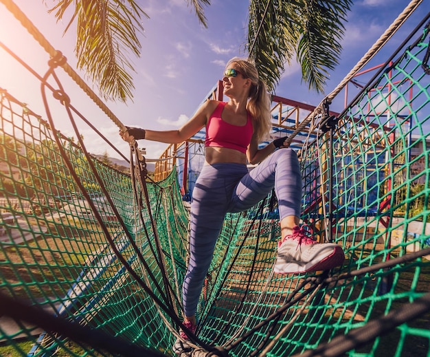 Athletic young woman working out at the rope training camp