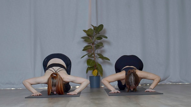 Athletic young women doing exercisizes for the spine stretching media concept of inner peace and no