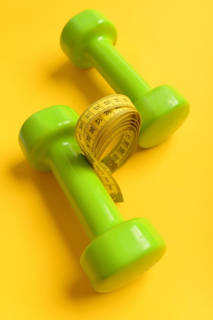 Фото Концепция легкой атлетики и похудения гантели ярко-зеленого цвета