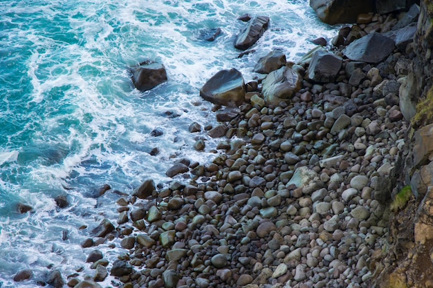 Atlantic Ocean Green Coast  and Rocky Beach with Waves Pattern of Sea, bridge in Husavik, Iceland