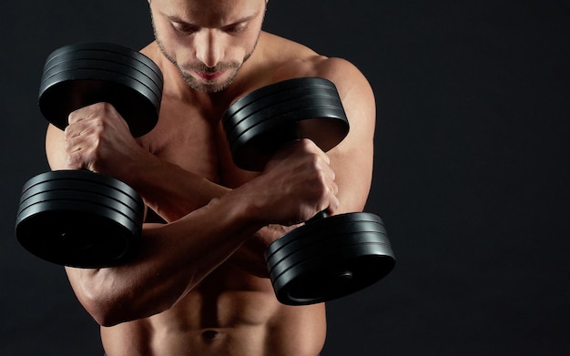 Atleet die dumbbells houdt met zijn handen gekruist