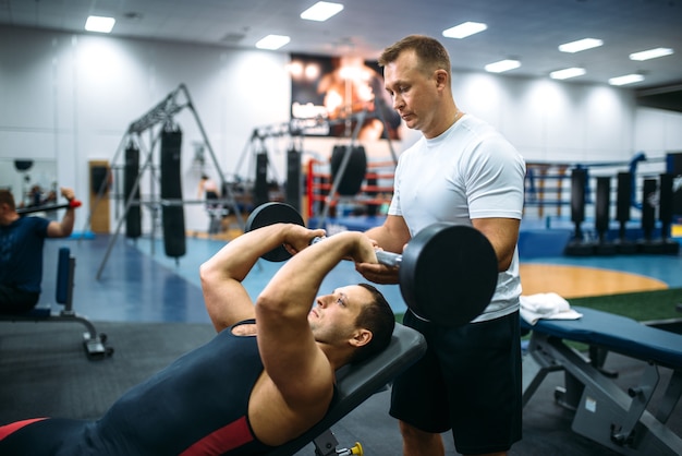 Atleet die oefeningen doet onder controle van de instructeur