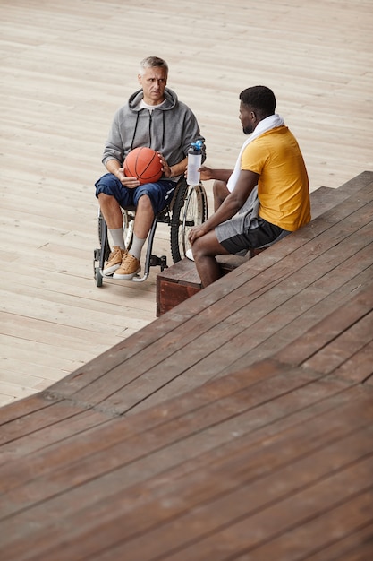 Atleet in gesprek met man met een handicap buitenshuis
