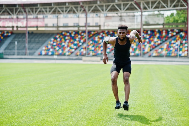 Atleet in sportkleding die sprongoefening doen bij stadion