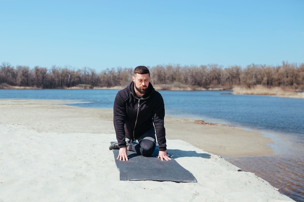 Atleet loper die zijn benen strekt voordat hij in de natuur gaat trainen