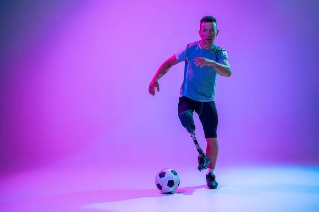 Atleet met een handicap of geamputeerde op studio achtergrond. voetballer