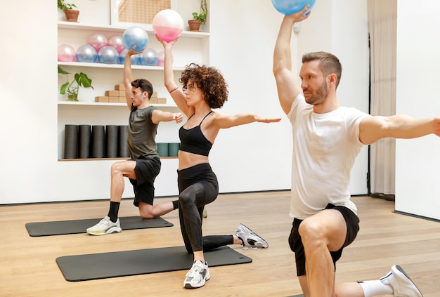 Atleten doen oefening met fluiball in fitnessstudio