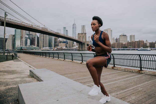 Atletenvrouw opleiding in de ochtend bij zonsopgang in de stad van New York