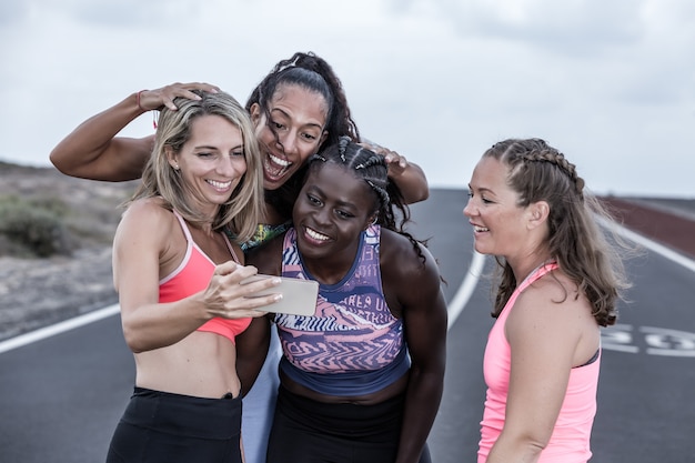 Foto atletenvrouwen die selfie op de weg nemen