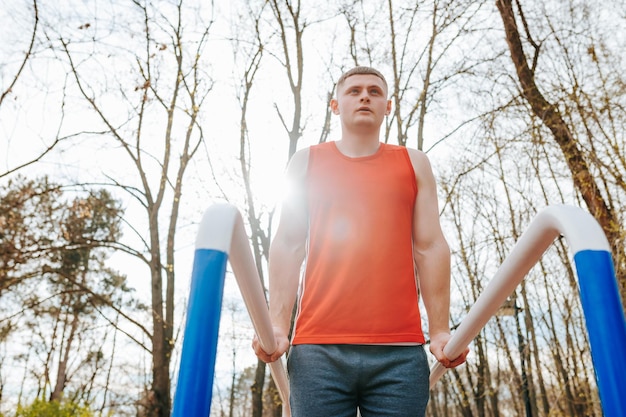 Atletiek in actie Een mannelijke sportman's gymnastiek routine Deze sterke atleet duwt zichzelf tot het uiterste met zijn strenge parallelle bars training allemaal terwijl hij buiten in de frisse lucht is