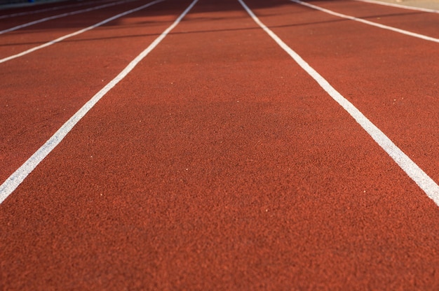 Atletiekbaan in het stadion. Rubberen coating. Loopband in de frisse lucht. Gezonde levensstijl concept. Atleten cardiotraining