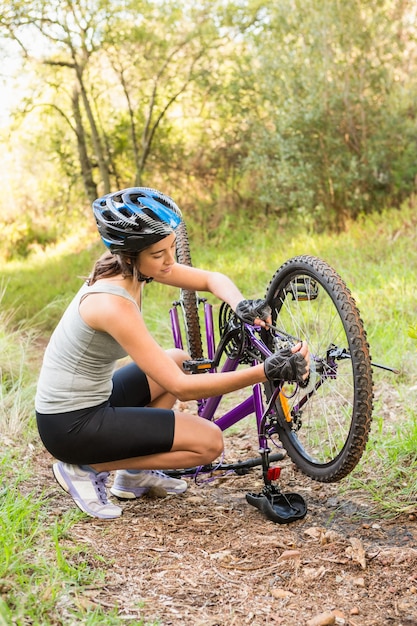 Atletisch brunette die haar bergfiets herstellen