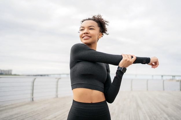 Atletisch lachend genieten van sport een jonge vrouw in een fitnesspak maakt zich klaar om te rennen is verloofd