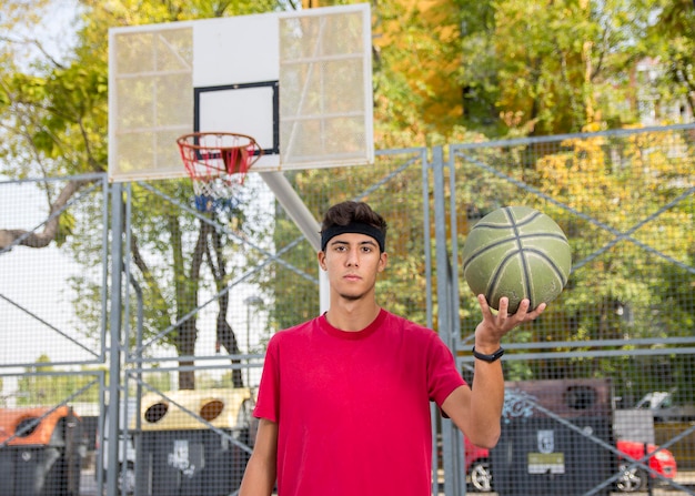 Atletisch mannetje dat buiten basketbal speelt.