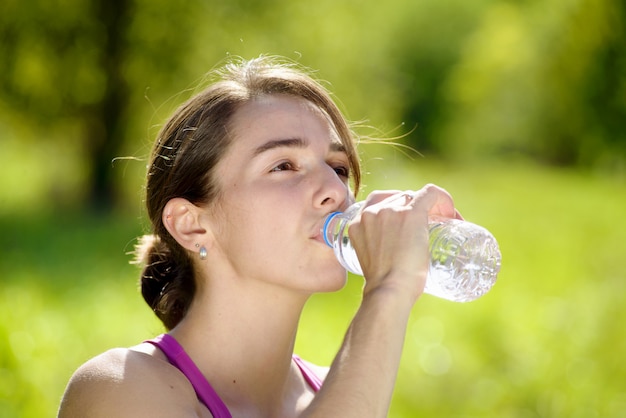 Atletisch meisjes drinkwater na het uitoefenen