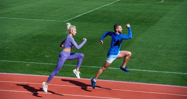 Atletisch paar sprinters rennen op atletiekbaan bij stadionsucces