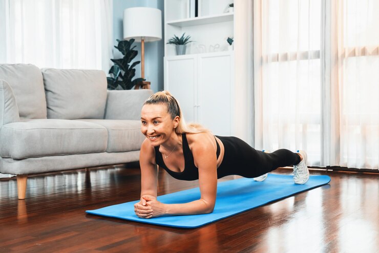 Foto atletische en sportieve senior vrouw planking op fitness oefenmat thuis oefenen als concept van een gezonde, fitte lichaamslevensstijl na pensionering