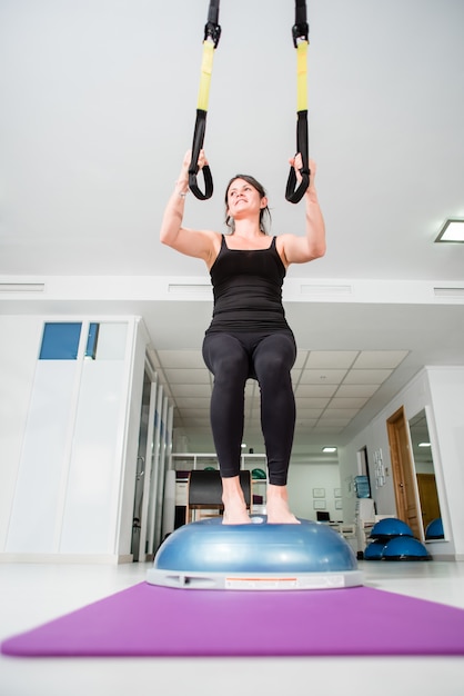 Atletische fit vrouw maakt TRX oefening