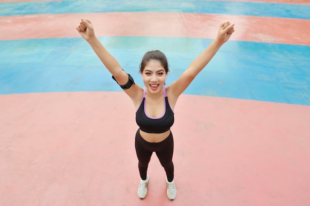 Atletische jonge gezonde en schoonheids aziatische vrouw in sportkleding die staat en handen buiten opsteekt voor ochtendoefening. Actief meisje trainen op biceps stretching oefening. Sport en lifestyle concept